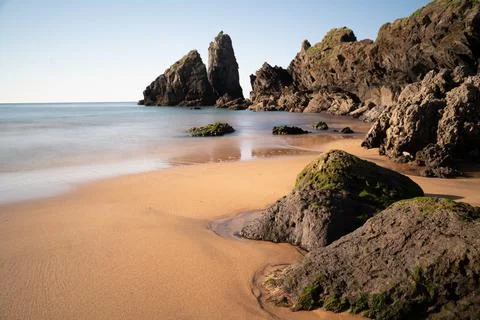 Vertical rock formation in a beach Stock Photos