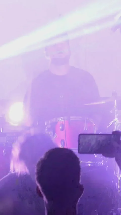 Vertical, A rock pop band is playing on stage. Listeners raised their hands up Stock Footage 300775948