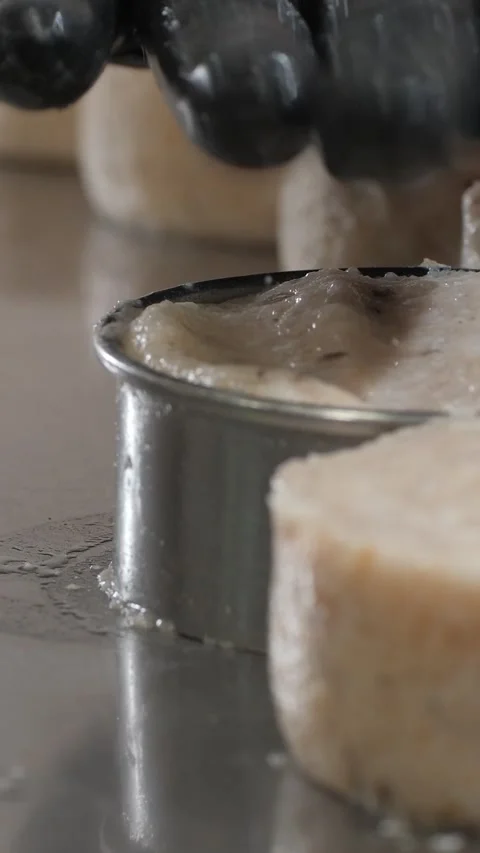 Vertical. Round metal mold presses fish mixture into uniform patties during Video stock 323705200