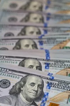 Vertical row of hundred US dollar bills with selective focus on Benjamin Fr.. Stock Photos
