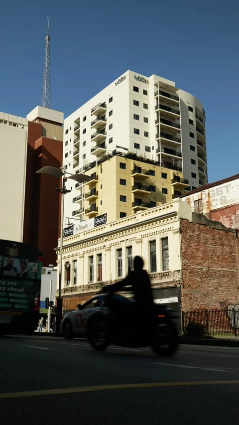 Vertical Run down building on Perth street corner and traffic 6K Vídeos de archivo 311493505