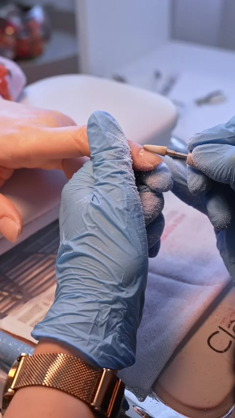 Vertical salon close-up of an electric nail bit refining a natural fingernail Vidéo 334013022