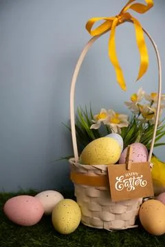 Vertical scene of basket full with eggs and yellow daffodil flowers Stock Photos