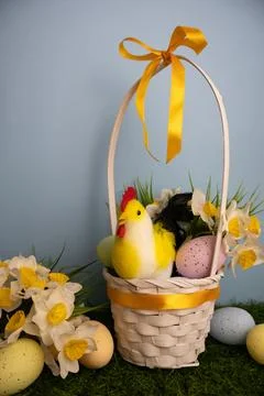 Vertical scene of an Easter basket with a chicken, pastel colorful eggs, and Stock Photos