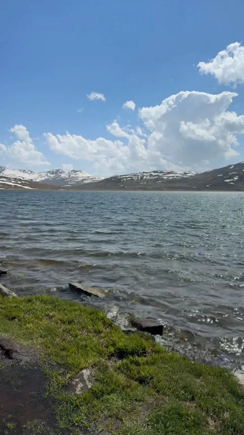 Vertical Scenic View of a Bright Alpine Lake under a Clear Blue Sky Stock Footage 329322554