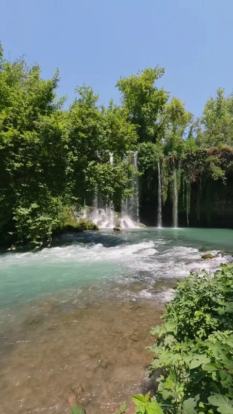 Vertical Scenic Waterfall Cascading Into Turquoise River in Forest Stock Footage 337794695