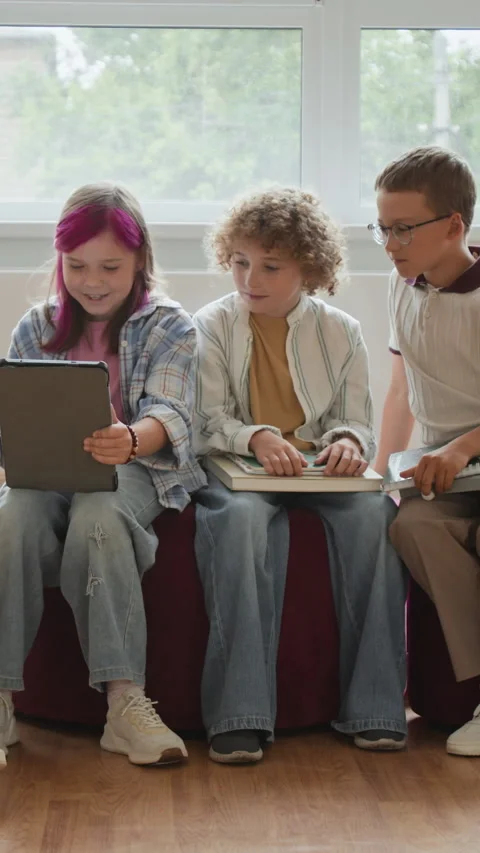 Vertical of Schoolchildren Using Digital Tablet for Collaborative Learning Stock Footage 345223060