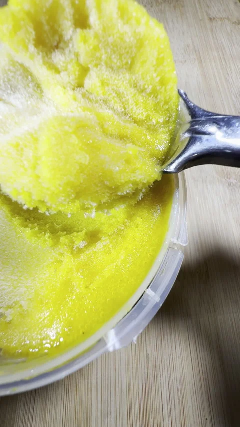 Vertical - A scoop tool taking a spoonful of yellow lemon sorbet from a carton. Stock Footage 296191219