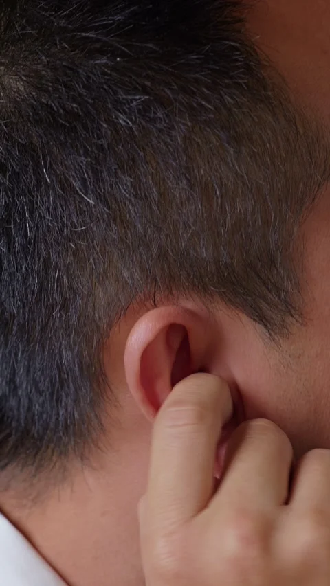 Vertical: Scratching itchy ear with hand. Stock Footage 345459281
