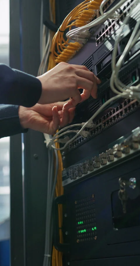 Vertical Screen Administrator Inserting Hardware in Server Racks in Stock Footage 320001399
