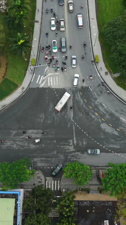 Vertical screen Aerial Hue Intersection Bus Skid Amid Commuters, Wet Asphalt Stock Footage 340000566