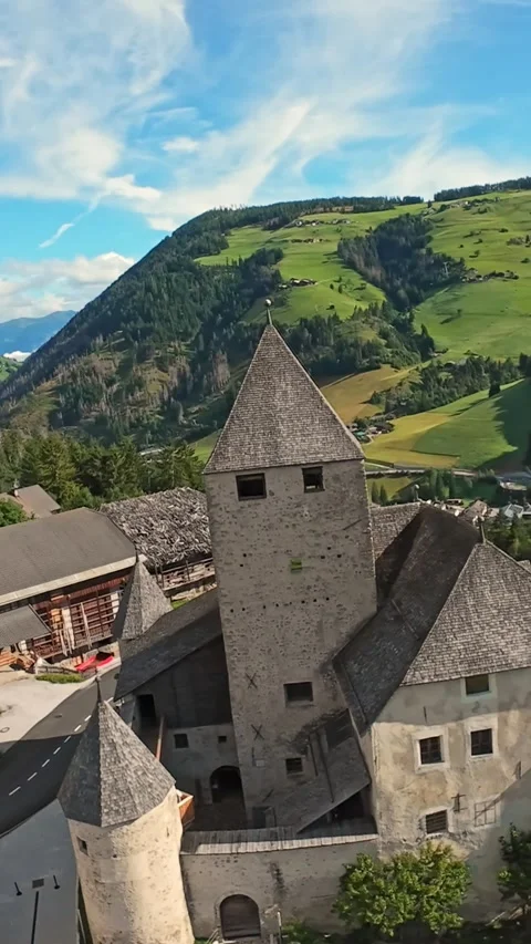 Vertical Screen Aerial Tower Above Green Alpine Slopes, Sunlit Turrets And Video stock 325059713