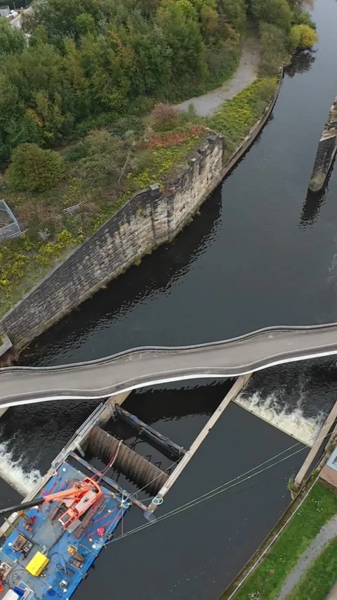Vertical screen Aerial View Weir Curved Footbridge Leeds, Maintenance Barge Vídeo Stock 335326257