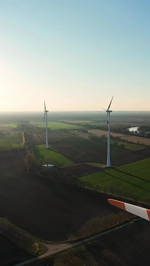 Vertical screen. Aerial view of wind turbines over farmlands during sunset Stock Footage 325825393