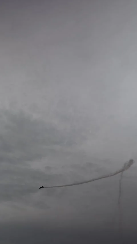 Vertical screen aerobatic plane pulls a sharp turn at the peak of a smoky vertic Stock Footage 311150094