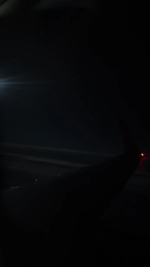Vertical screen airplane wingtip glows in the dark sky as stars faintly shimmer  Stock Footage 310467477