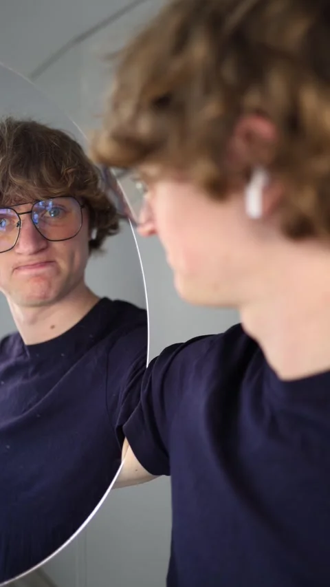 Vertical screen annoyed young man glares at his reflection pressing his lips tog Stock Footage 313268869