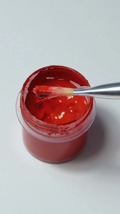 Vertical Screen: the artist picks up red paint on a transparent palette on a Stock Footage 229966527