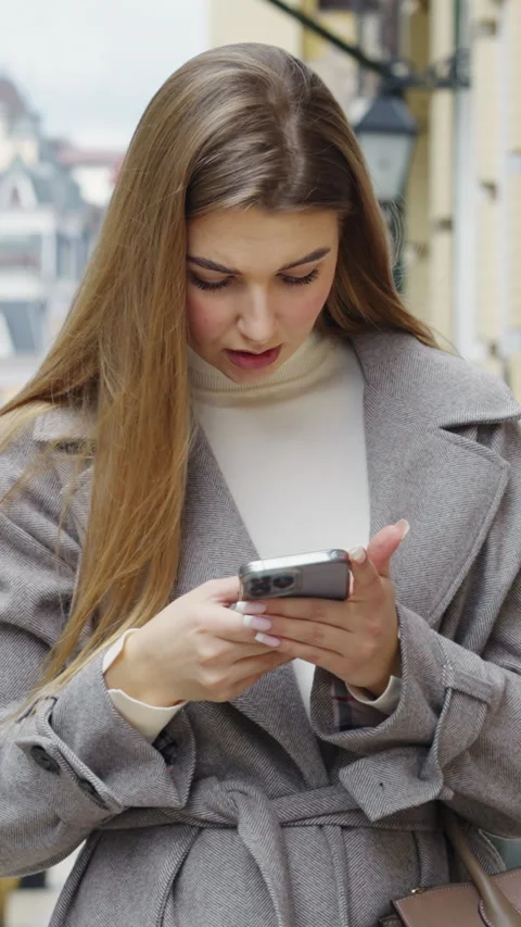 Vertical Screen: Beautiful blonde chatting with smartphone at street in autumn Stock Footage 293102623