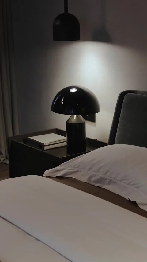 Vertical screen: a bedside table with a black lamp. Modern minimalist bedroom Stock Footage 310242075