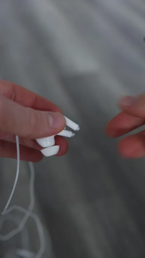 Vertical screen broken white earphones held in fingers snapped connector exposed Stock Footage 306007231
