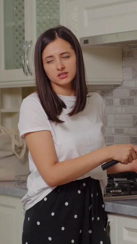 Vertical Screen Brunette cutting a green pepper in the kichen. Vidéo 299986935