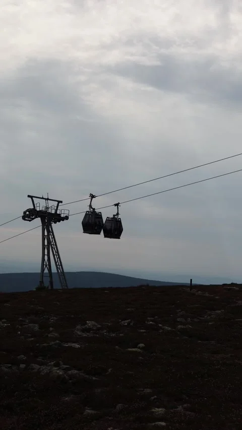 Vertical screen cable car moves across misty mountain landscape under cloudy sky Stock Footage 315940213