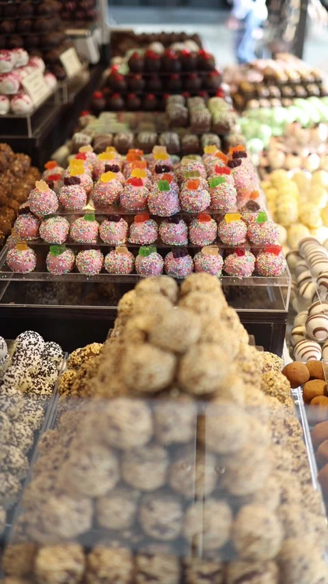 Vertical screen candy-covered marzipan treats with gummy bears on top surrounded Video stock 306677973