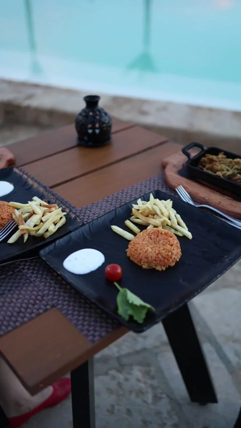Vertical screen casual poolside meal with rice patties crispy fries creamy sauce 스톡 동영상 310056330