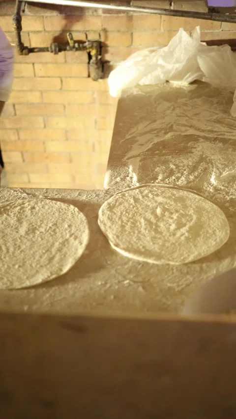 Vertical screen Chef shapes raw pizza dough on floured counter with quick skille Stock Footage 310020024