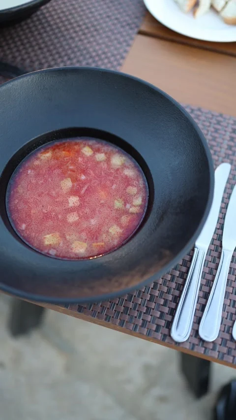 Vertical screen chilled beetroot soup with diced vegetables served in a deep mat Stock Footage 310056243