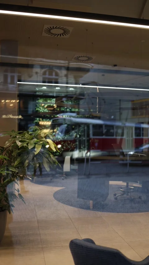 Vertical screen: A city tram reflected in the glass facade of a modern office, b Stock Footage 300162412
