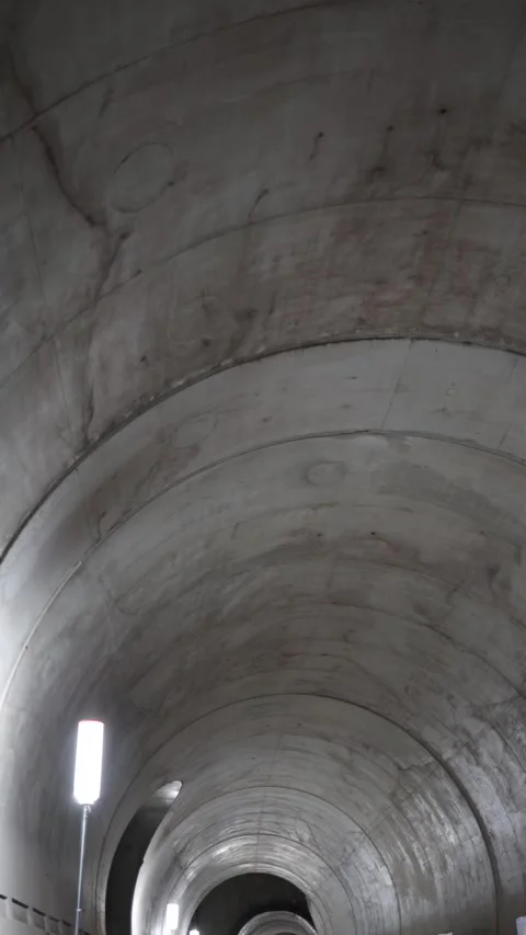 Vertical screen clean metro tunnel curves into distance with smooth concrete sur Stock Footage 309542385