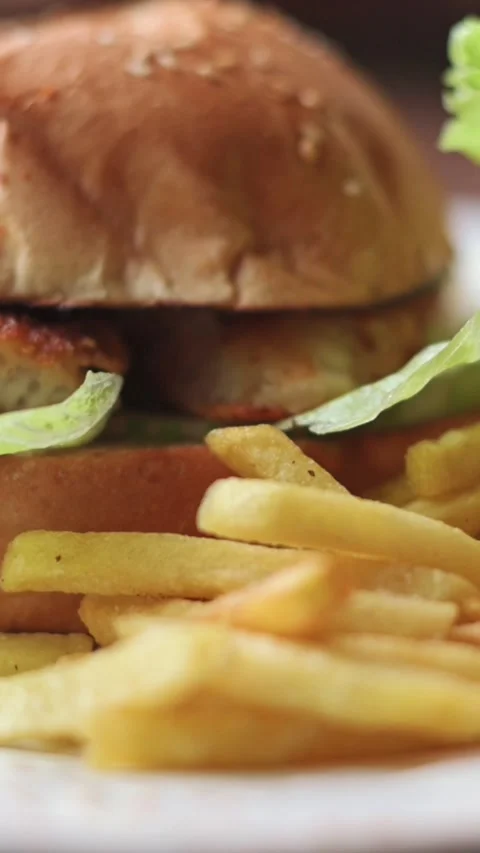Vertical screen. Close-up of crispy chicken burger with lettuce in toasted Video stock 306715532