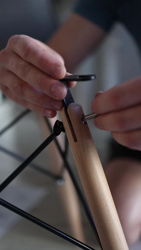 Vertical screen close up of hands assembling modern wooden furniture using metal Stock Footage 310010143