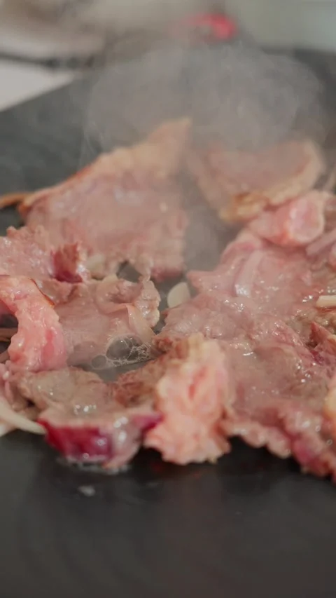 Vertical screen close-up pan-fried thin slices of roast beef and shredded onions Stock Footage 341650579