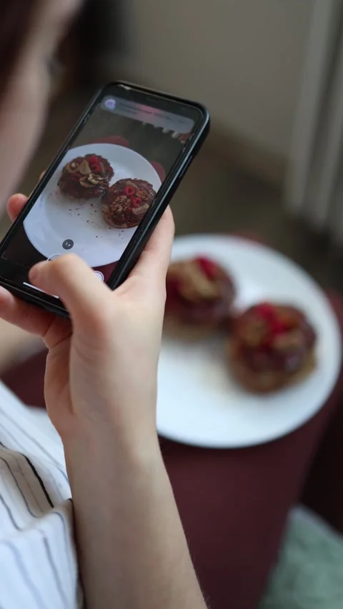 Vertical screen: Close-up of a person photographing festive Easter pastries with Stock Footage 305295261