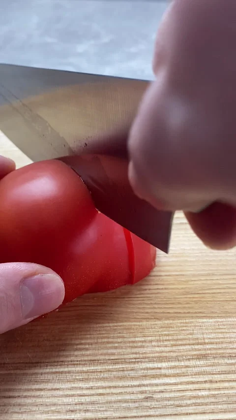 Vertical screen: Close up shot of chef's hands cutting a fresh tomato with knife Stock Footage 237706688