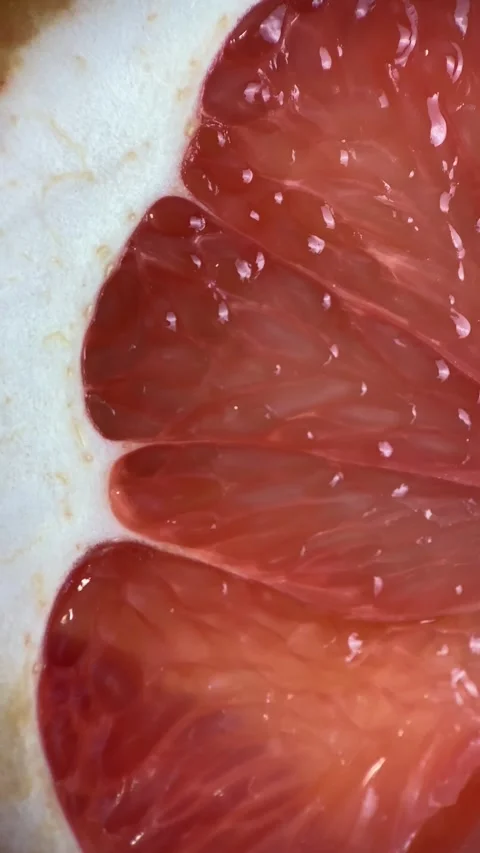 Vertical screen: Close up of sliced ripe grapefruit, macro. Red fresh grapefruit Stock Footage 265500291