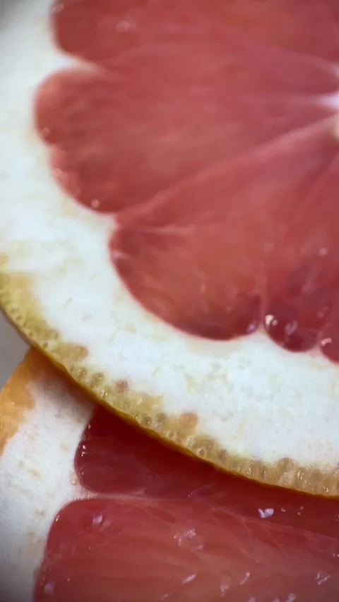 Vertical screen: Close up of sliced ripe grapefruit, macro. Red fresh grapefruit Stock Footage 265500610