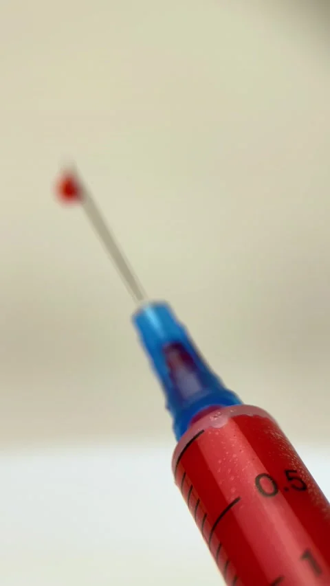 Vertical screen: Close up of a syringe drawing blood. Drawing Blood into a Stock Footage 236755414