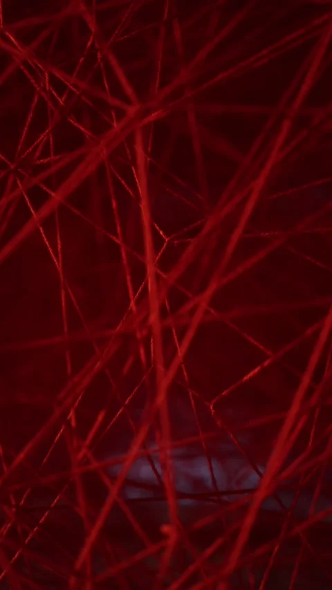 Vertical screen: A close-up of tangled red threads forming an abstract pattern.  Video stock 304459348