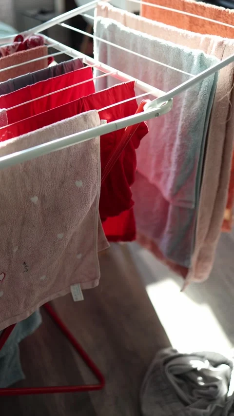 Vertical screen: A close-up view of colorful towels and garments drying on a clo Stock Footage 301240695