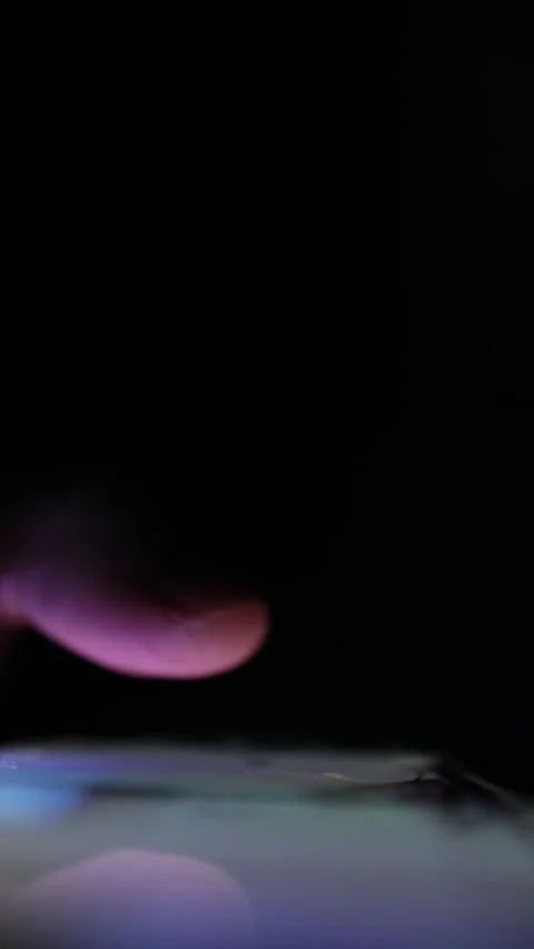 Vertical screen Closeup of finger slowly swiping on glowing phone screen in comp Stock Footage 313842806