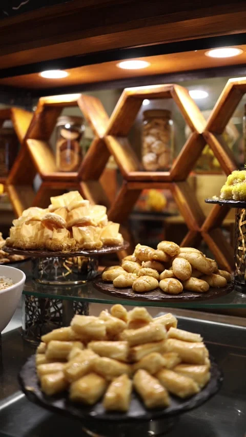 Vertical screen Closeup of golden baklava stacked on elegant black platter glist Stock Footage 310016887
