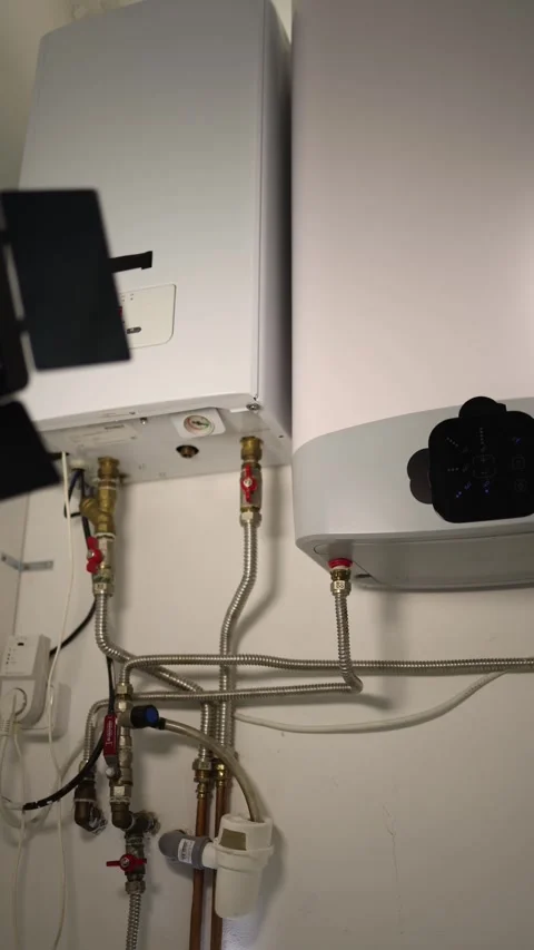 Vertical screen closeup of heating boiler and water tank connected with metal pi Stock Footage 318867742