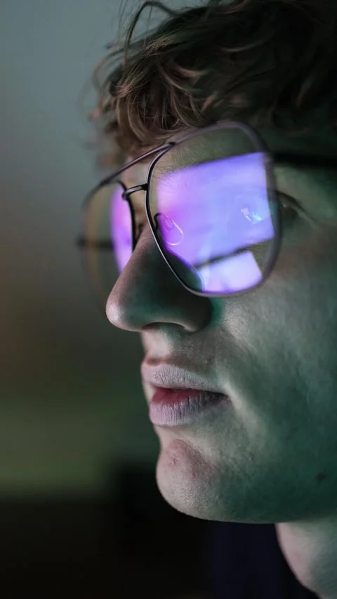 Vertical screen closeup of man wearing glasses with reflections of computer scre Stock Footage 316878136