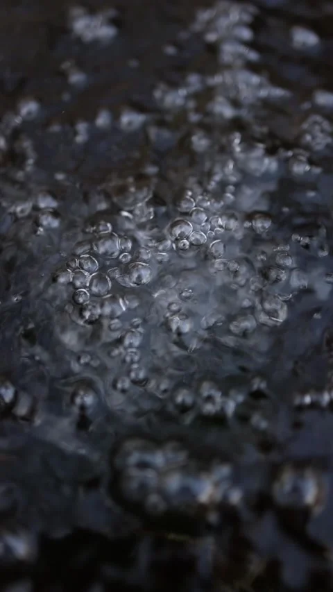 Vertical screen closeup water bubbles dark surface air pressure texture fluid mo Stock Footage 306007477