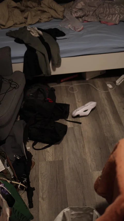 Vertical screen: A cluttered bedroom with scattered clothes, bags, and a shoe on Video stock 299308367