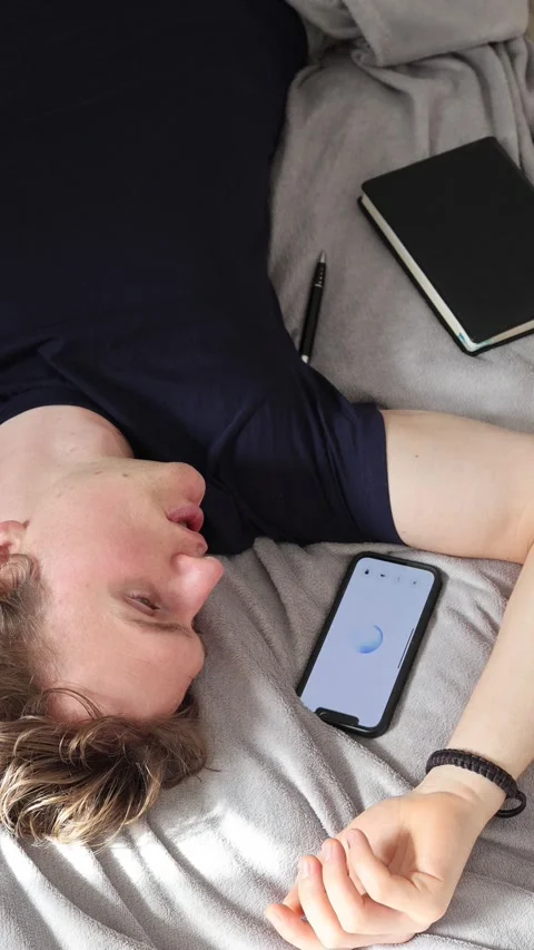 Vertical screen communication with artificial intelligence young man lies on bed Stock Footage 314979516